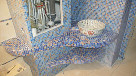 Полки и стены ванной комнаты, отделанные мозаикой