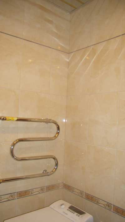 Отделка ванной комнаты: плиточное покрытие стен и полотенцесушитель